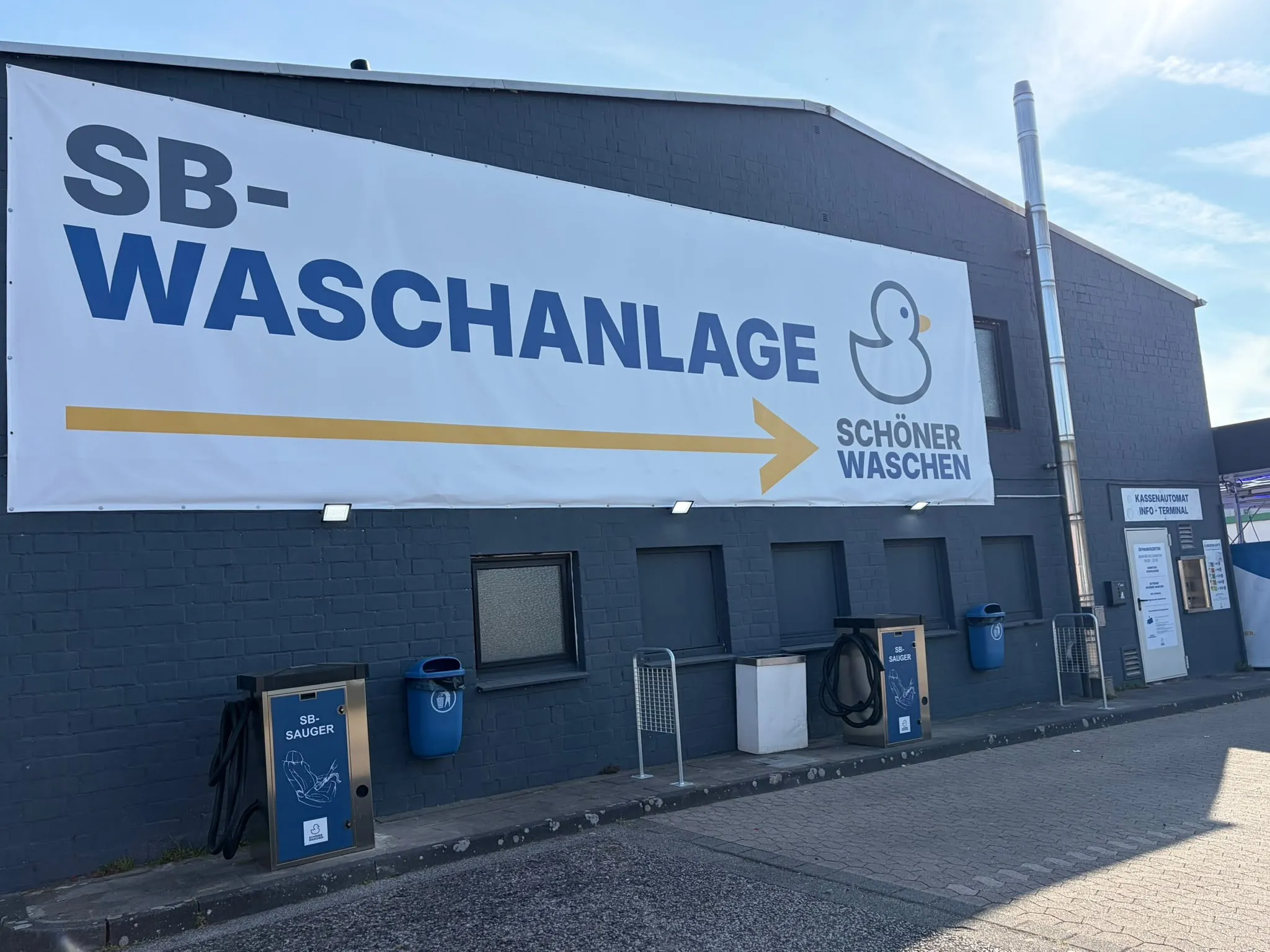 Die Halle des Waschparks Kaarst mit dem großen Schriftzug „SB-Waschanlage – Schöner Waschen“